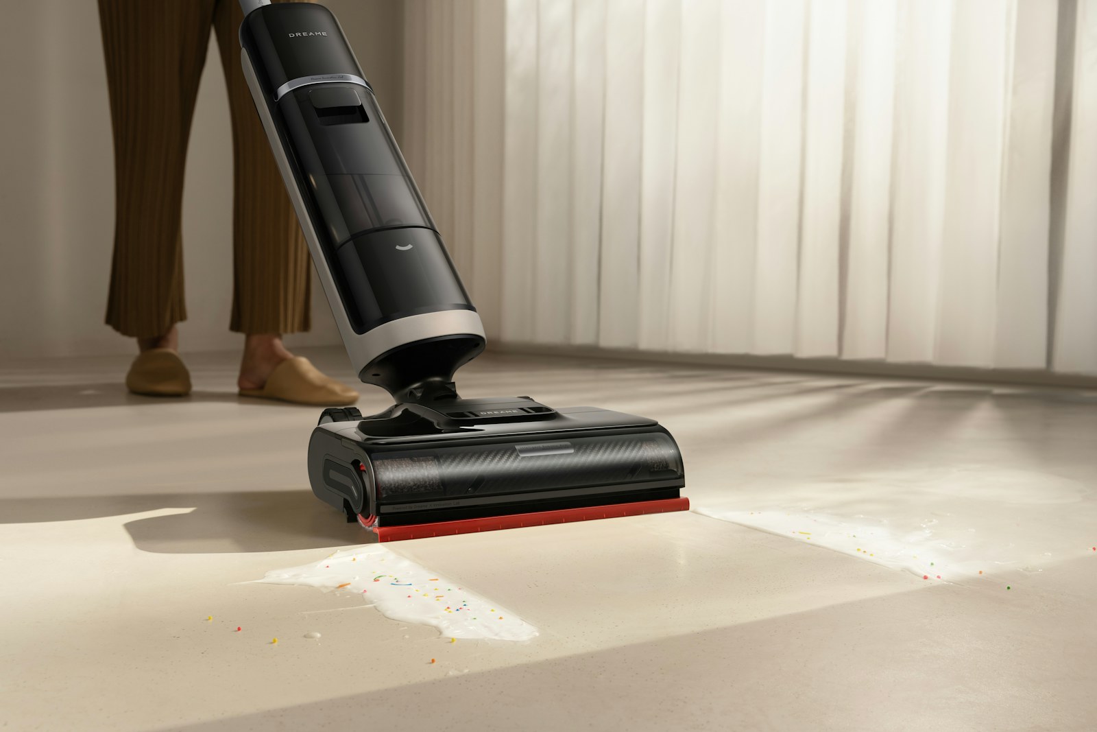 A wet-dry floor cleaner moving over water on a hard floor